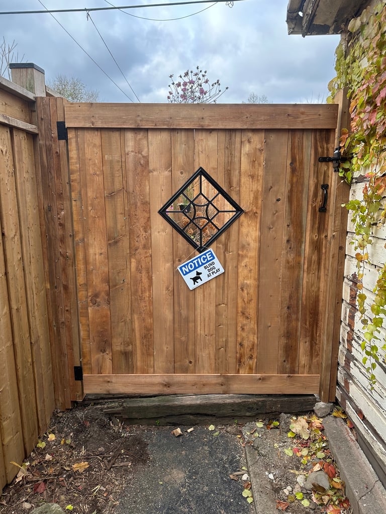 Wooden gate with decorative diamond pattern and private notice sign in an enclosed yard space